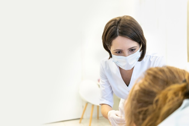 Il cosmetologo esamina le procedure mediche dell'esame dentistico di consultazione dei medici pazienti