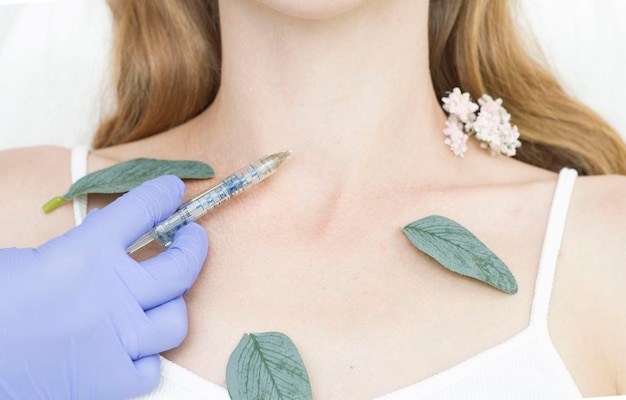 Il cosmetologo fa iniezioni antietà contro le rughe sulla zona del collo e del décolleté Cosmetologia estetica femminile