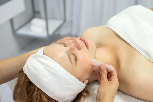 Il cosmetologo fa un massaggio facciale con una serie di gouache
