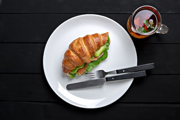 Il croissant del panino nel piatto per la prima colazione si chiuda