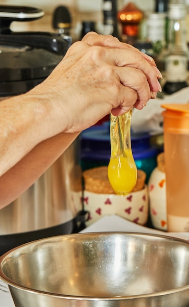 Il cuoco aggiunge un uovo alla ciotola degli ingredienti per preparare il piatto