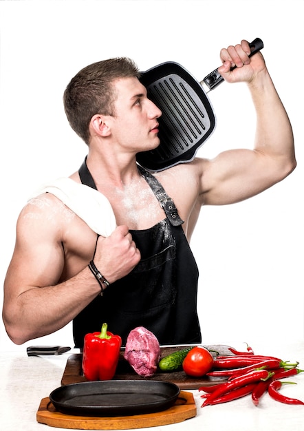 Il cuoco bodybuilder prepara un pranzo a base di verdure e carne.