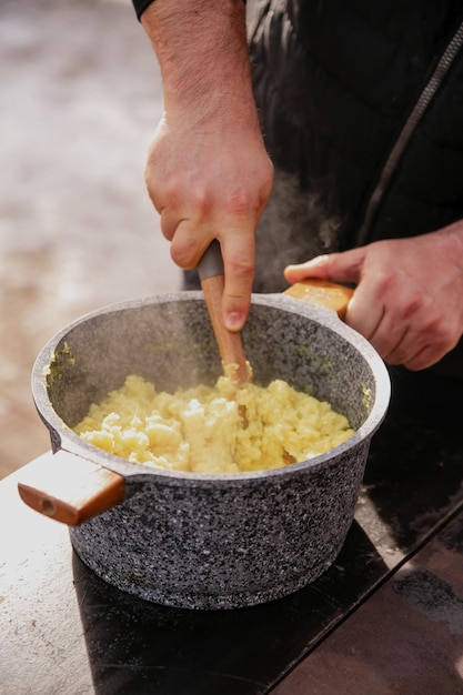 Il cuoco cucina all'aperto in inverno un bel vapore da un piatto appena cucinato