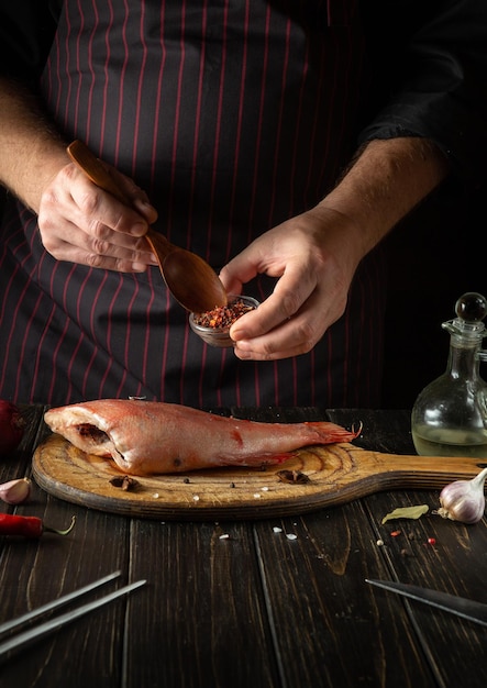 Il cuoco prepara il pesce Sebastes in cucina Il concetto di cottura di alimenti a base di pesce per un ristorante