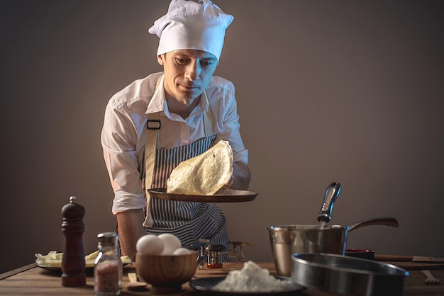 Il cuoco sta lanciando un pancake in aria per girarlo