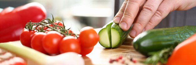 Il cuoco taglia verdure fresche e succose per l'insalata