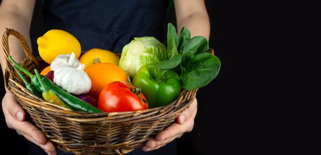 Il cuoco tiene in mano un cesto di frutta e verdura. Cucinando . Mangiare sano Ottimo cibo. Cibo vegetariano. Bandiera. Sfondo di cibo.