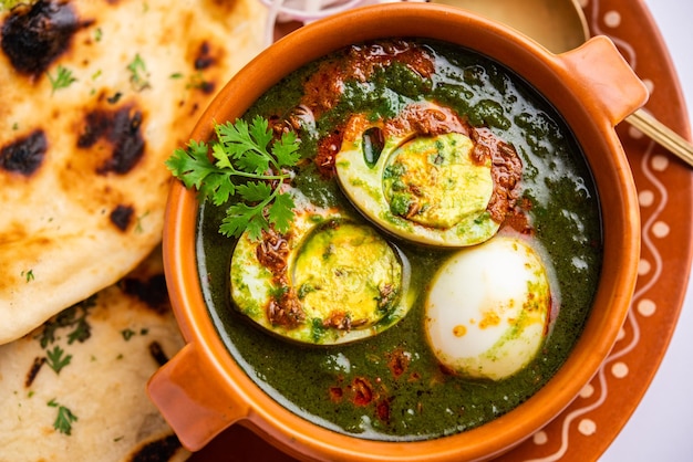 Il curry di uova di spinaci è un piatto indiano non vegetariano preparato con sugo di palak con uova