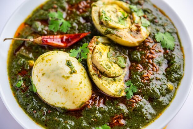 Il curry di uova di spinaci è un piatto indiano non vegetariano preparato con sugo di palak con uova