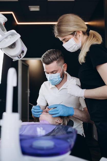 Il dentista controlla molto attentamente e ripara il dente della sua giovane paziente
