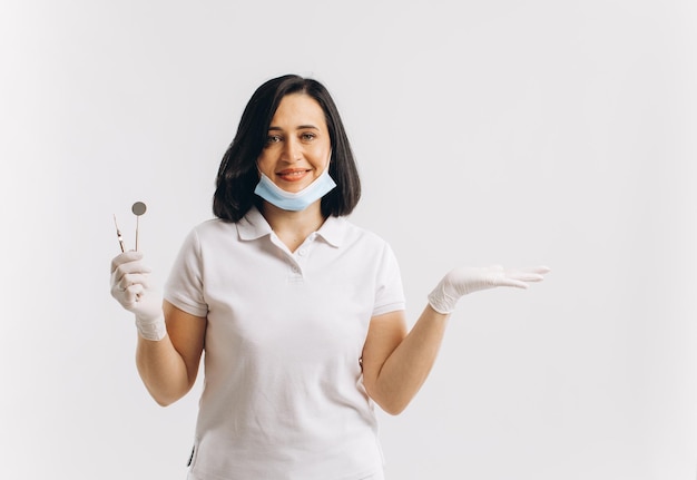 Il dentista della donna in una maschera medica mostra qualcosa su uno spazio della copia