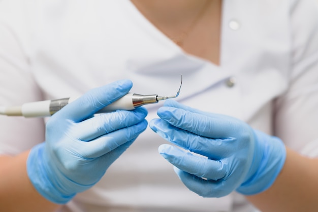 Il dentista e il suo assistente mostrano diversi strumenti medici. medico dentista femminile che tiene gli strumenti nelle sue mani