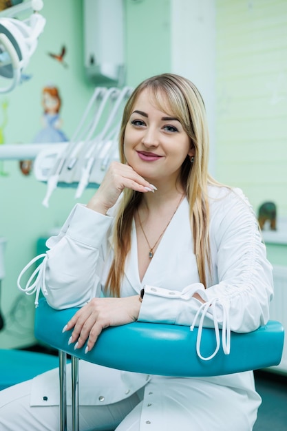 Il dentista è nel suo studio dentistico Dentista donna in camice bianco Studio dentistico