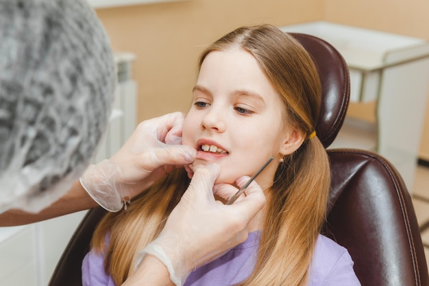 Il dentista esamina i denti del bambino nel concetto di medicina e odontoiatria della poltrona