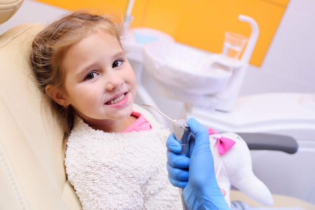 Il dentista esamina i denti di un bambino su una poltrona del dentista.