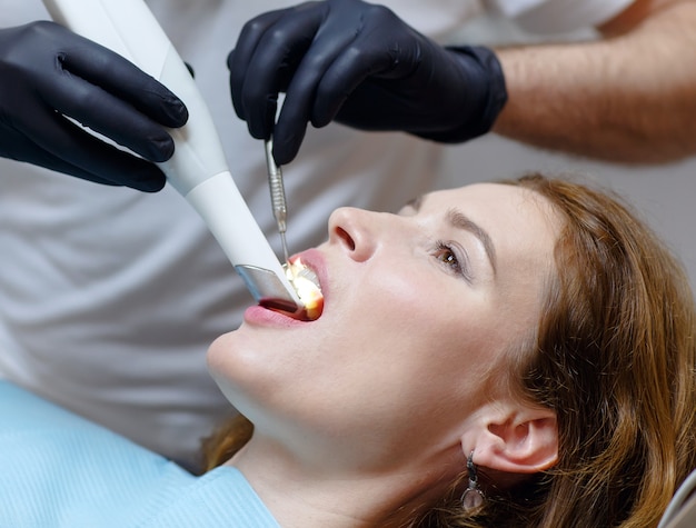 Il dentista esegue la scansione dei denti del paziente con uno scanner 3d.