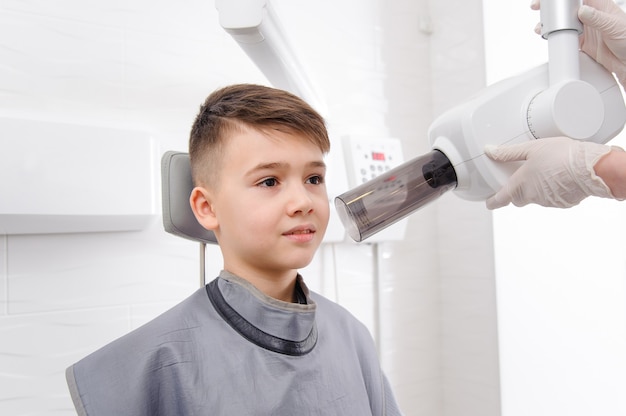 Il dentista fa l'immagine dei raggi x della mascella per il ragazzino in clinica dentale