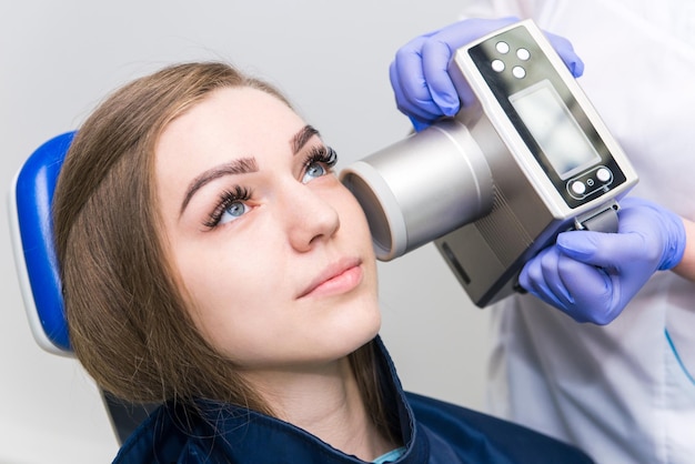 Il dentista fa l'immagine dei raggi x della mascella per la ragazza nella clinica odontoiatrica