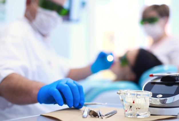 Il dentista maschio senior regola il proiettore prima di iniziare il lavoro