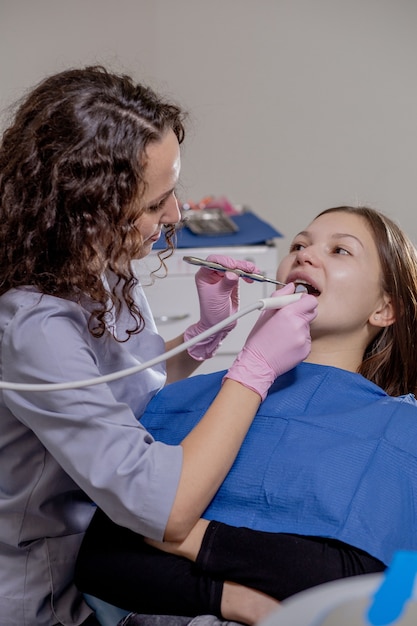 Il dentista professionista esamina e tratta i denti viziati con l'uso di strumenti dentali speciali, attrezzature mediche. Concetto di denti sani.