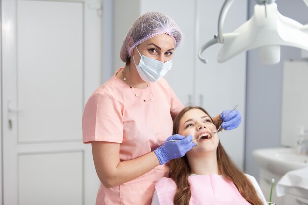 Il dentista professionista esamina i denti di un paziente in una clinica dentale Il concetto di cura dentale