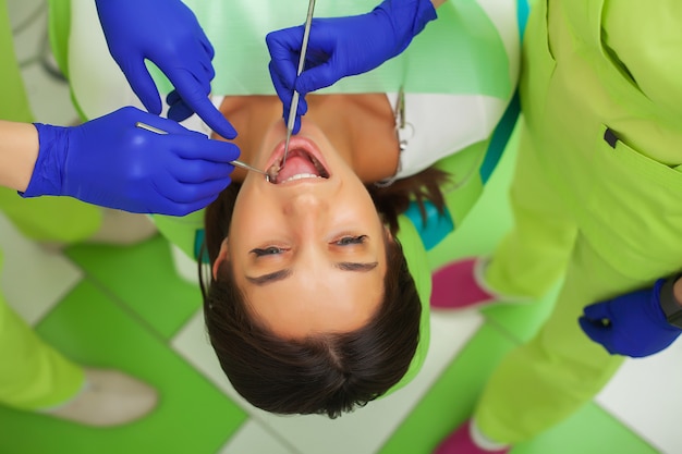 Il dentista sta trattando i denti al cliente in studio dentistico