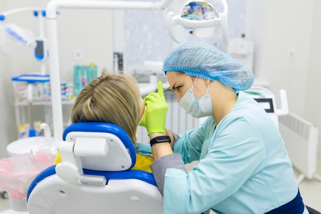 il dentista trapani il dente inferiore al paziente seduto su una sedia