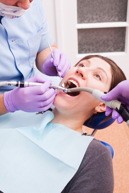 Il dentista tratta i denti con l'aiuto di strumenti dentali