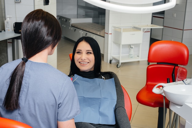 Il dentista tratta i denti della ragazza al paziente. Odontoiatria