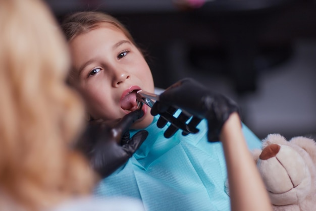 Il dentista usa l'iniezione di anestetico per l'estrazione del dente nel bambino.