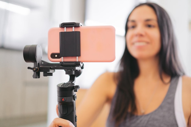 Il dettaglio ha ripreso uno smartphone tenuto da un gimbal utilizzato da una donna sfocata per effettuare una videochiamata