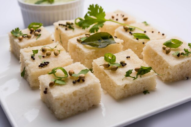 Il dhokla bianco khaman a base di riso o urad dal è una ricetta popolare per la colazione o gli snack del Gujarat, in India, servita con chutney verde e tè caldo. Messa a fuoco selettiva