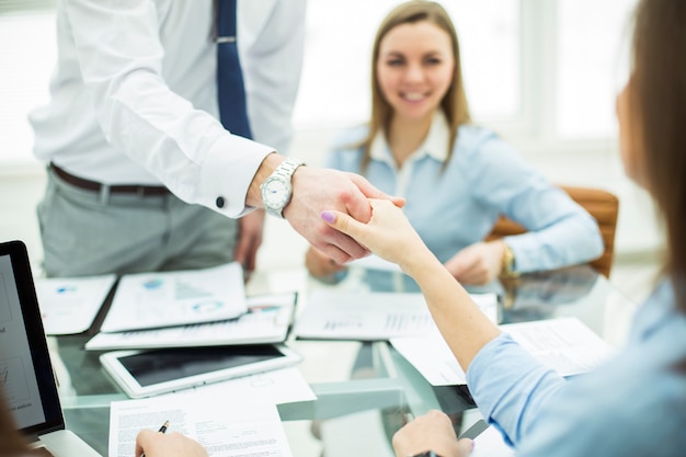 Il direttore di banca e il cliente si stringono la mano dopo aver firmato un lucroso contratto