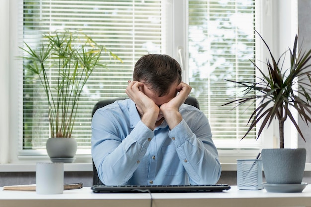 Il direttore nel suo ufficio si stropiccia gli occhi stancamente. Il giovane si siede sul posto di lavoro e si strofina gli occhi. Lavoro in ufficio e problemi agli occhi.