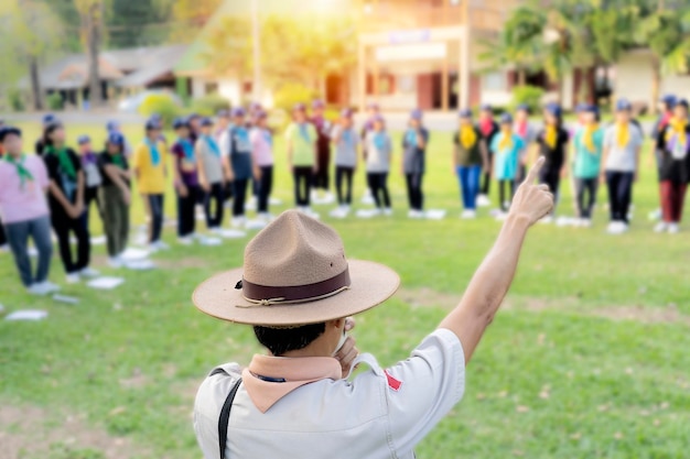 Il direttore scout insegna attività nel mezzo del prato Campi di addestramento scout nella provincia di Nakhon Nayok in Thailandia Costume tradizionale da boy scout