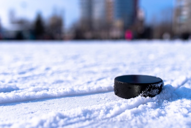 Il disco da hockey nero si trova sul ghiaccio allo stadio