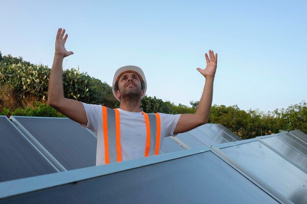 il disperato lavoratore del pannello solare urla con le mani sulla testa.