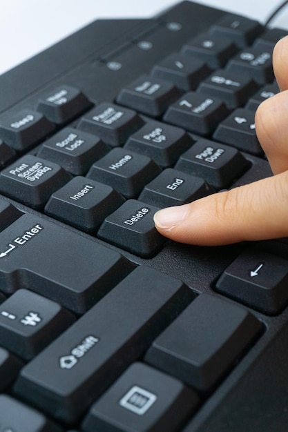 Il dito di una donna che tiene la tastiera di un computer