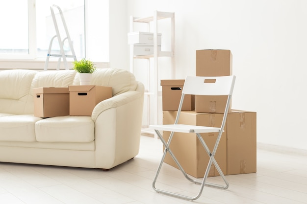 Il divano e le scatole della sedia pieghevole si trovano nel nuovo soggiorno quando i residenti si trasferiscono in un nuovo appartamento. Il
