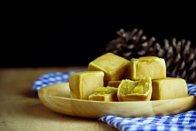 Il dolce cinese taglia a forma di e ha modellato il fiore del pino disposto sulla tavola di legno