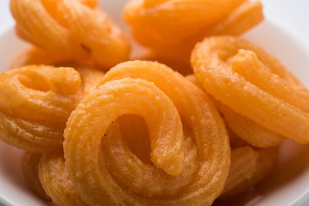 Il dolce Paneer Jalebi è servito in un piatto di ceramica su uno sfondo colorato o in legno. Messa a fuoco selettiva