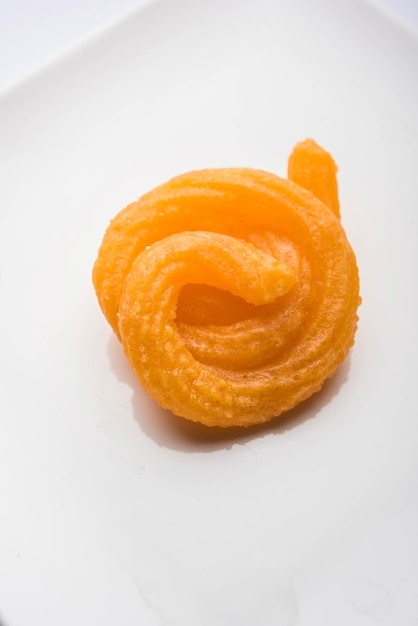 Il dolce Paneer Jalebi è servito in un piatto di ceramica su uno sfondo colorato o in legno. Messa a fuoco selettiva