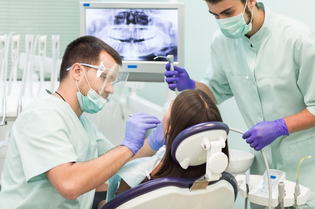 Il dottore dentista con un assistente lavora in una clinica dentale.