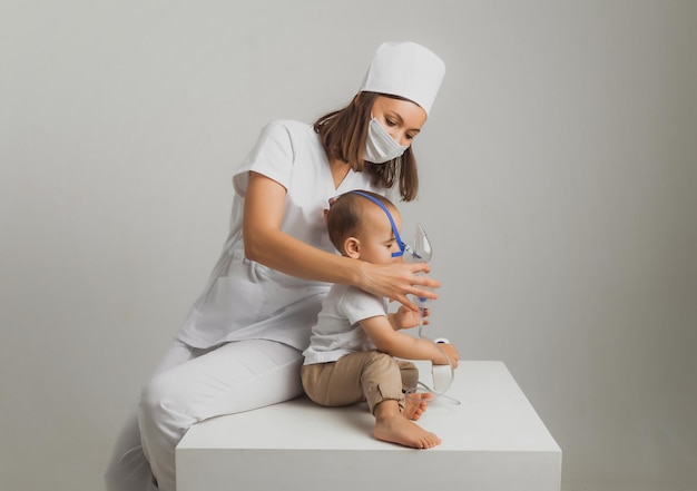 Il dottore fa una procedura di inalazione per un bambino. foto in studio di alta qualità. medicina per bambini