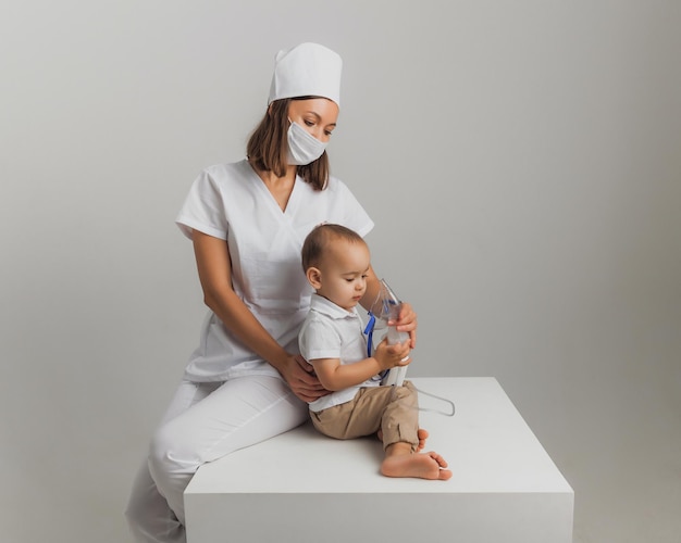 Il dottore fa una procedura di inalazione per un bambino. foto in studio di alta qualità. medicina per bambini