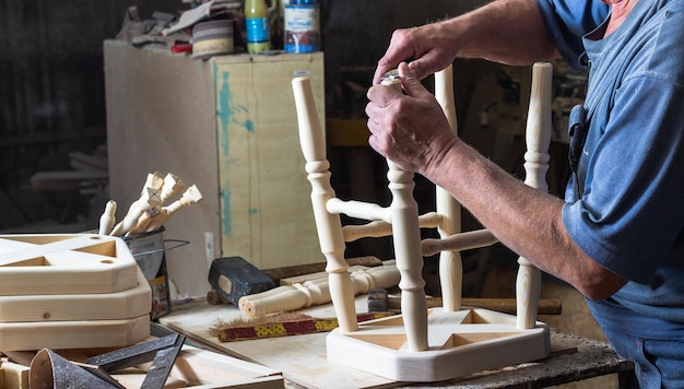 il falegname assembla una sedia di legno su un banco da lavoro