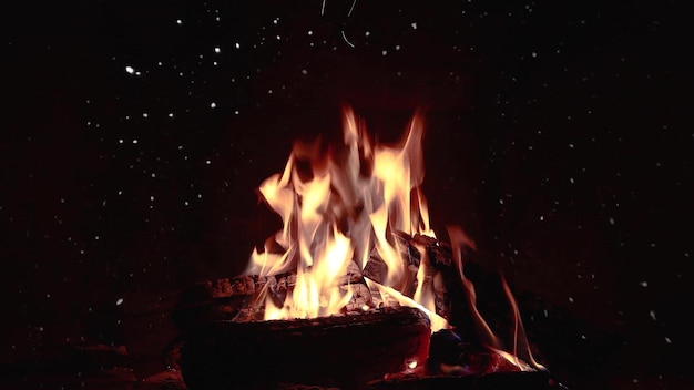 Il falò brucia di notte sullo sfondo di montagne e mare con stelle luminose