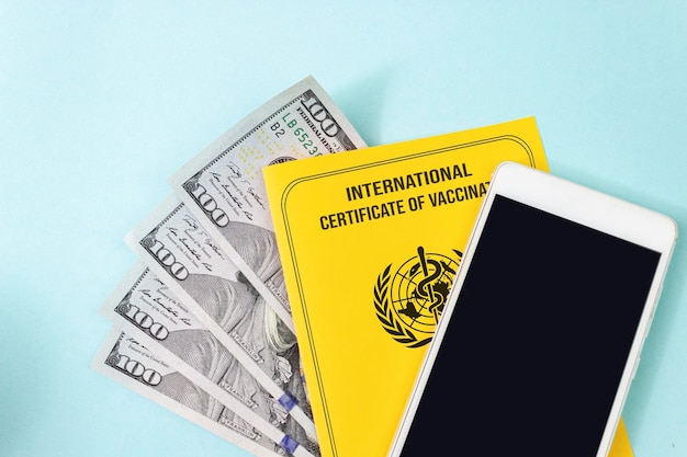 Il falso certificato internazionale giallo di vaccinazione guadagna soldi con uno smartphone vuoto con schermo mock up Concetto di passaporto per l'immunità alle malattie vaccinali