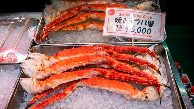 Il famoso mercato del pesce di Tsukiji con negozi al dettaglio vendono gambe di granchio e frutti di mare a Tokyo. Mercato esterno, il più grande mercato di pesce all'ingrosso del mondo