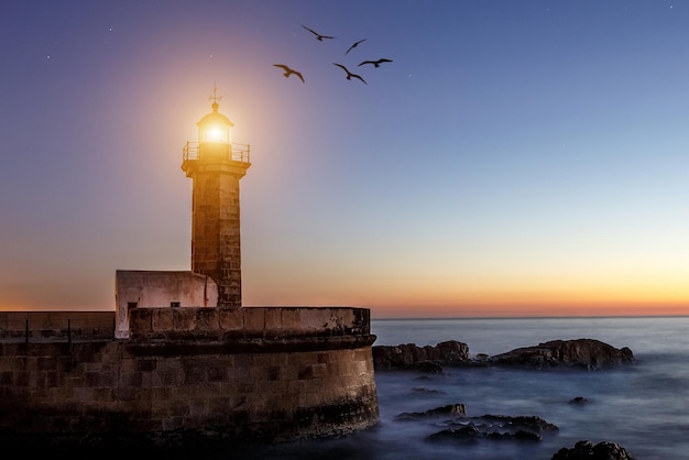 Il faro con la luce girata e gli uccelli che volano intorno